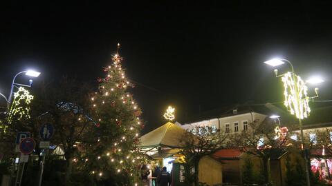 bunt-geschmueckter-christbaum-am-weihnachtsmarkt