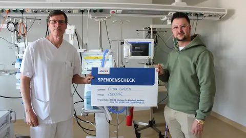 Philipp Rößler von der Firma Cartelo (r.) überreichte den Spendenscheck an Dr. Daniel   
Vilser, Chefarzt der Klinik für Kinder- und Jugendmedizin im AMEOS Klinikum St. Elisabeth   
Neuburg  