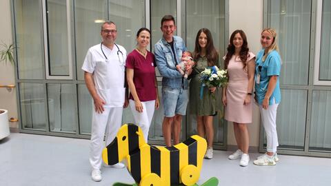  v.l. Teodor Florin Legian, Leitender Oberarzt, Sabine Nießl-Birkmeier, Hebamme B.Sc., Sabine Schmidt, Leitung Projektmanagement (2. v.r.) und Lisa Leinfelder, Stellvertretende Stationsleitung (r.) gratulierten der glücklichen Familie (Mitte) bestehend aus Mutter Lena Kurzhals, Vater Maximilian Schmidl, und dem kleinen Johannes Kurzhals  