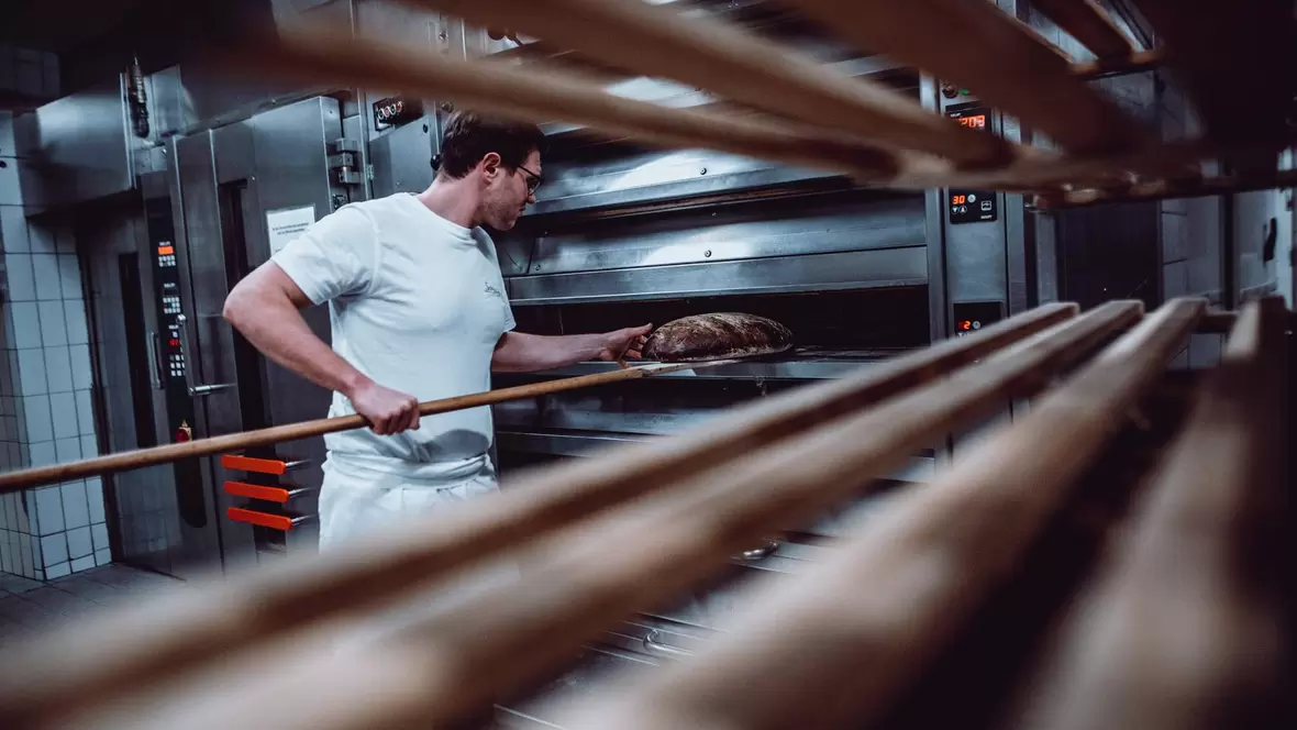 baecker-beim-brot-backen-in-der-baeckerei-schlegl