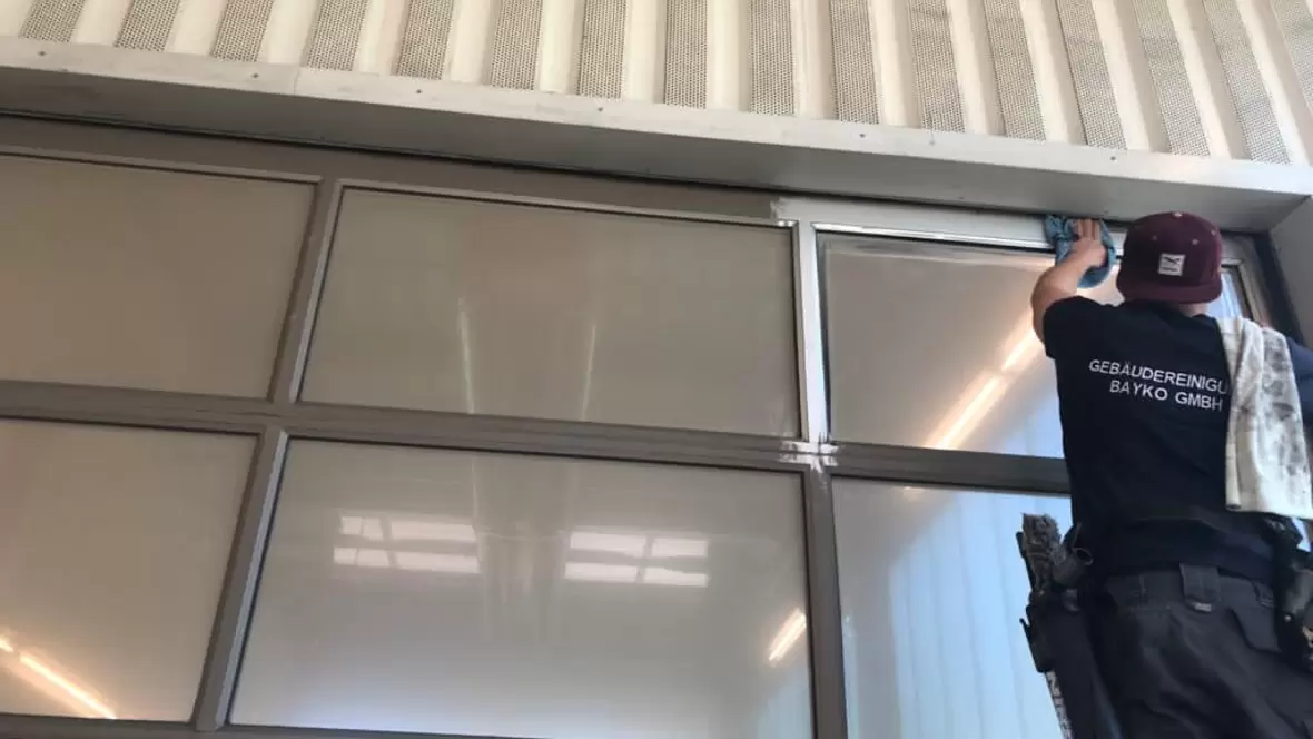 bayko-gebaeudereinigung-mann-bei-der-fensterreinigung