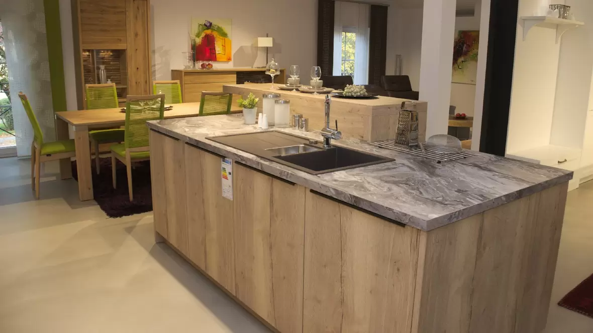 kueche-mit-zentraler-arbeitsplatte-aus-stein-mit-waschbecken-und-schraenken